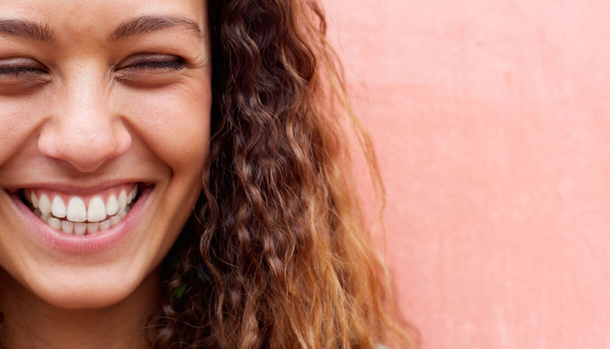 smiling woman peach background